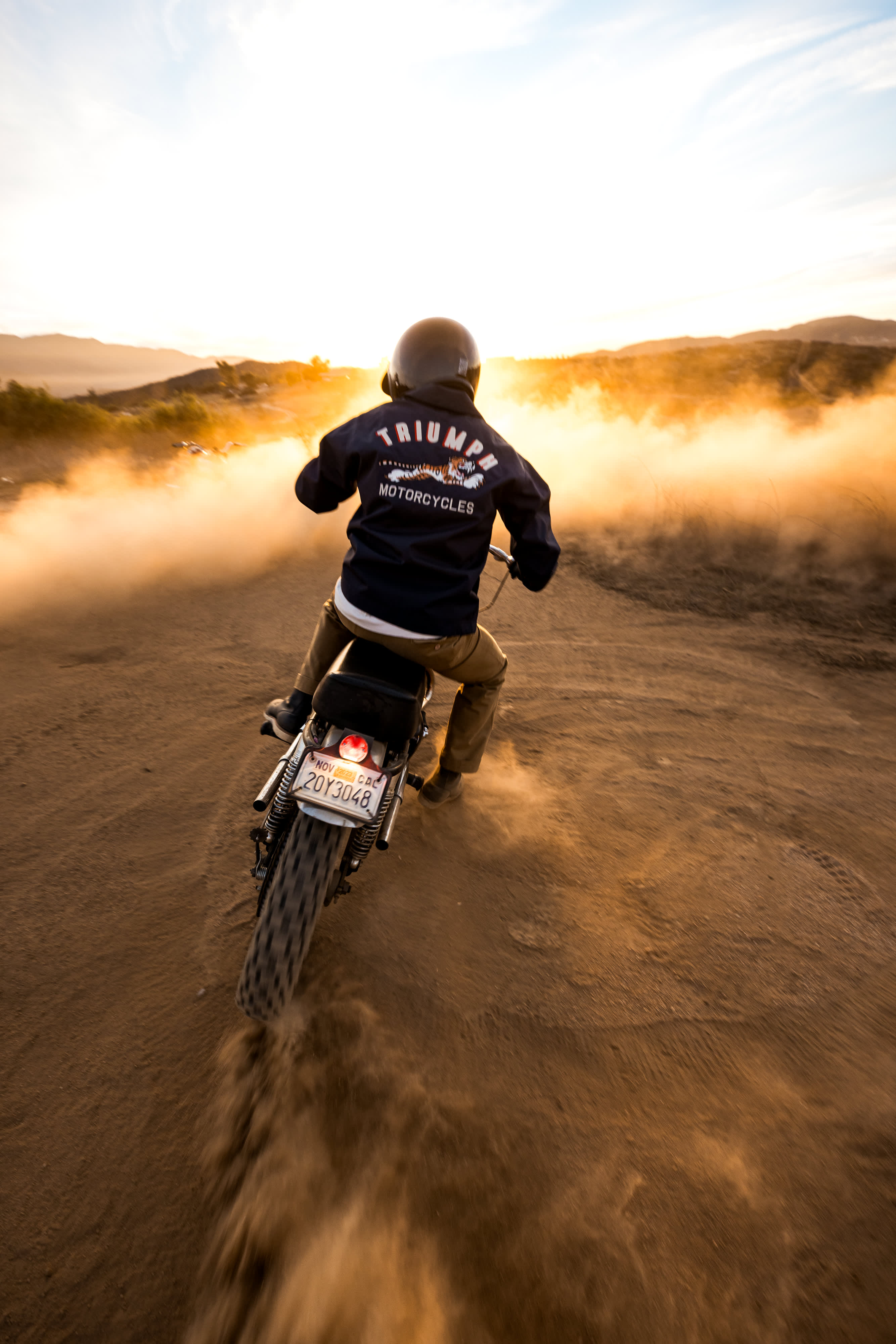 Man in desert riding a Triumph Motorcycle