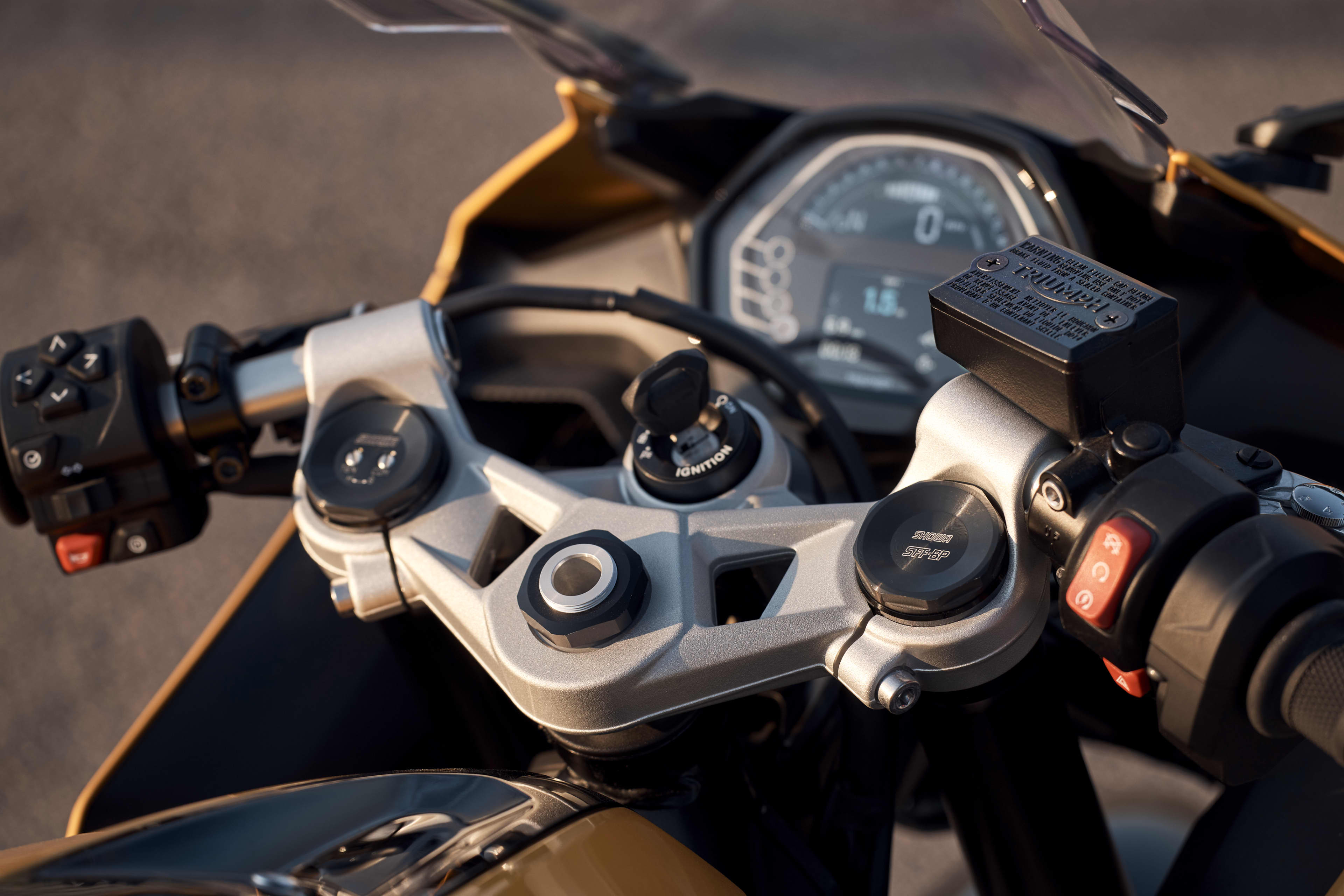 Close up of the Triumph Daytona 660 cockpit with handlebars, ignition and digital instrument cluster