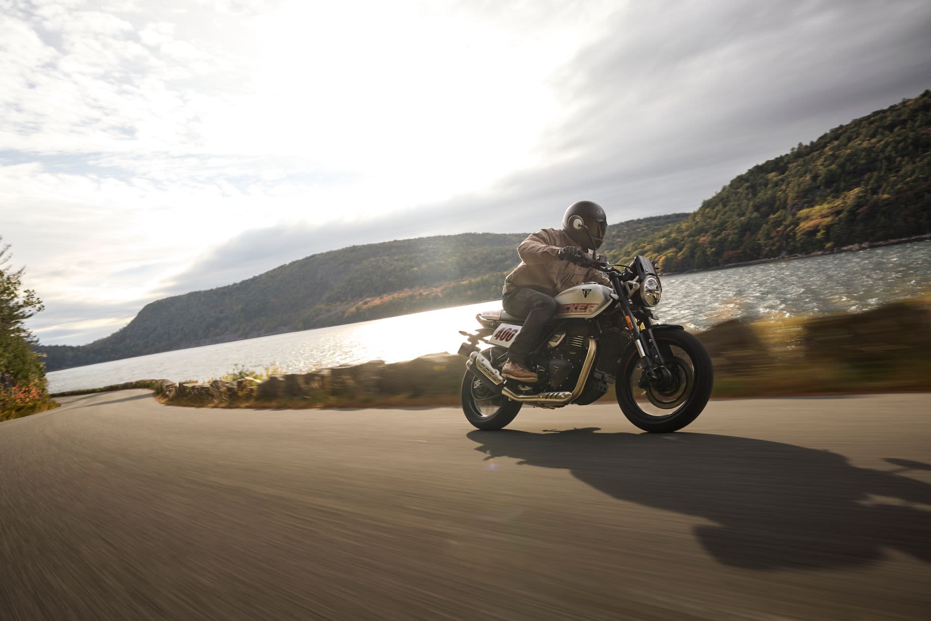 Triumph Tracker 400 being ridden at speed down a country lane.