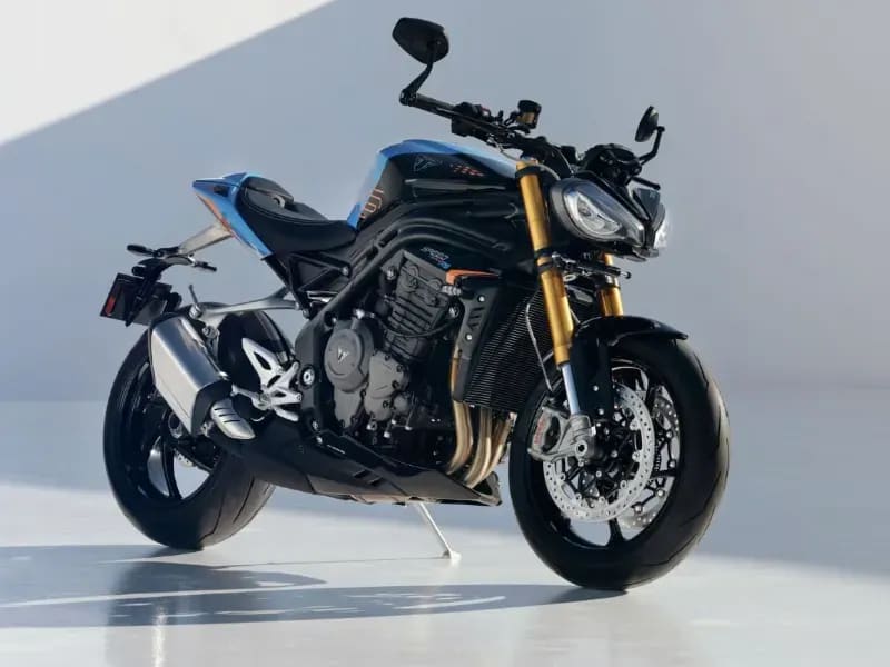 A Triumph Speed Triple 1200 RS sports motorcycle parked in a minimalist white studio with dramatic shadows and blue accents.