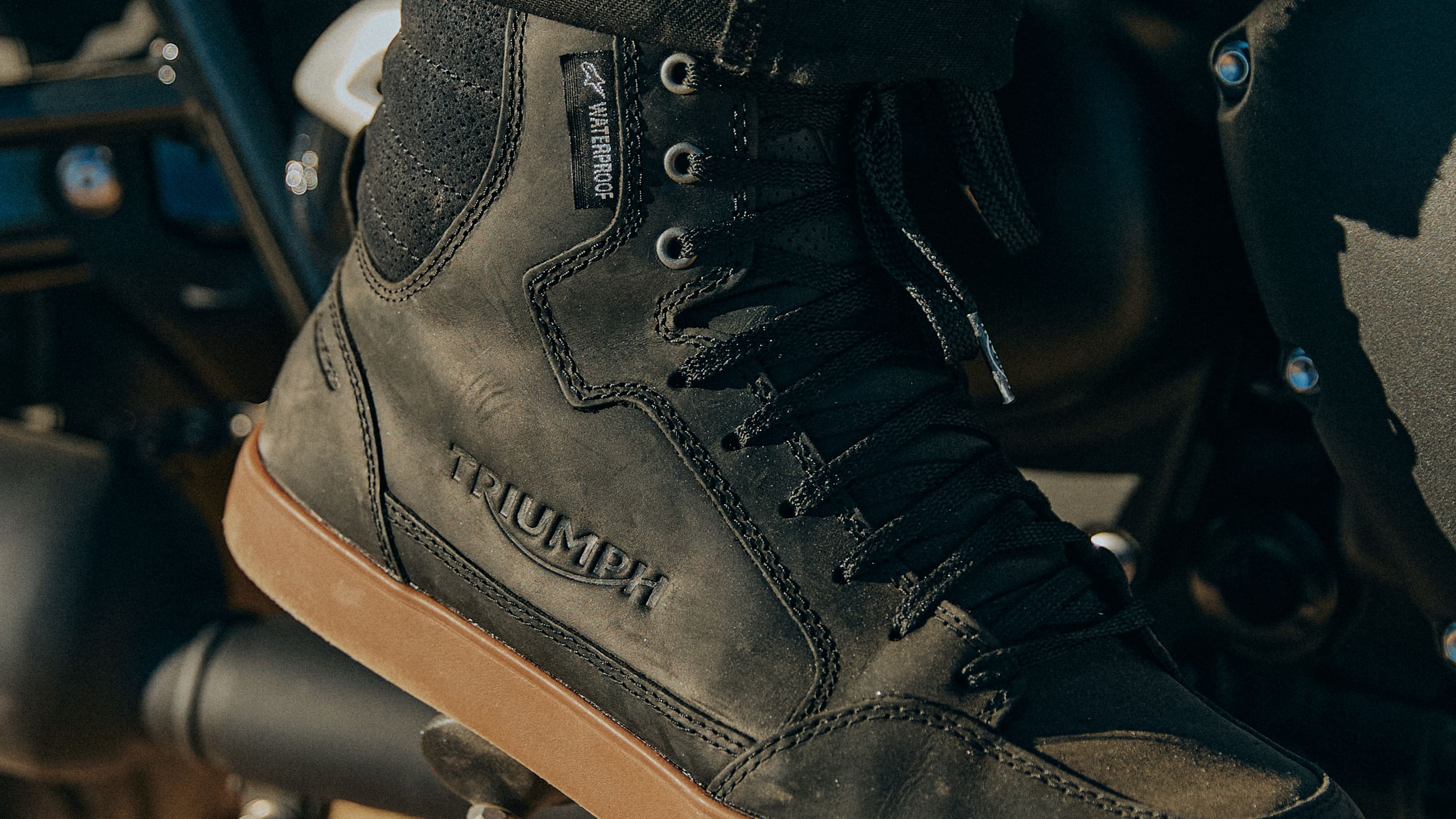 Triumph blue racing checkerboard long sleeve t-shirt on a rock