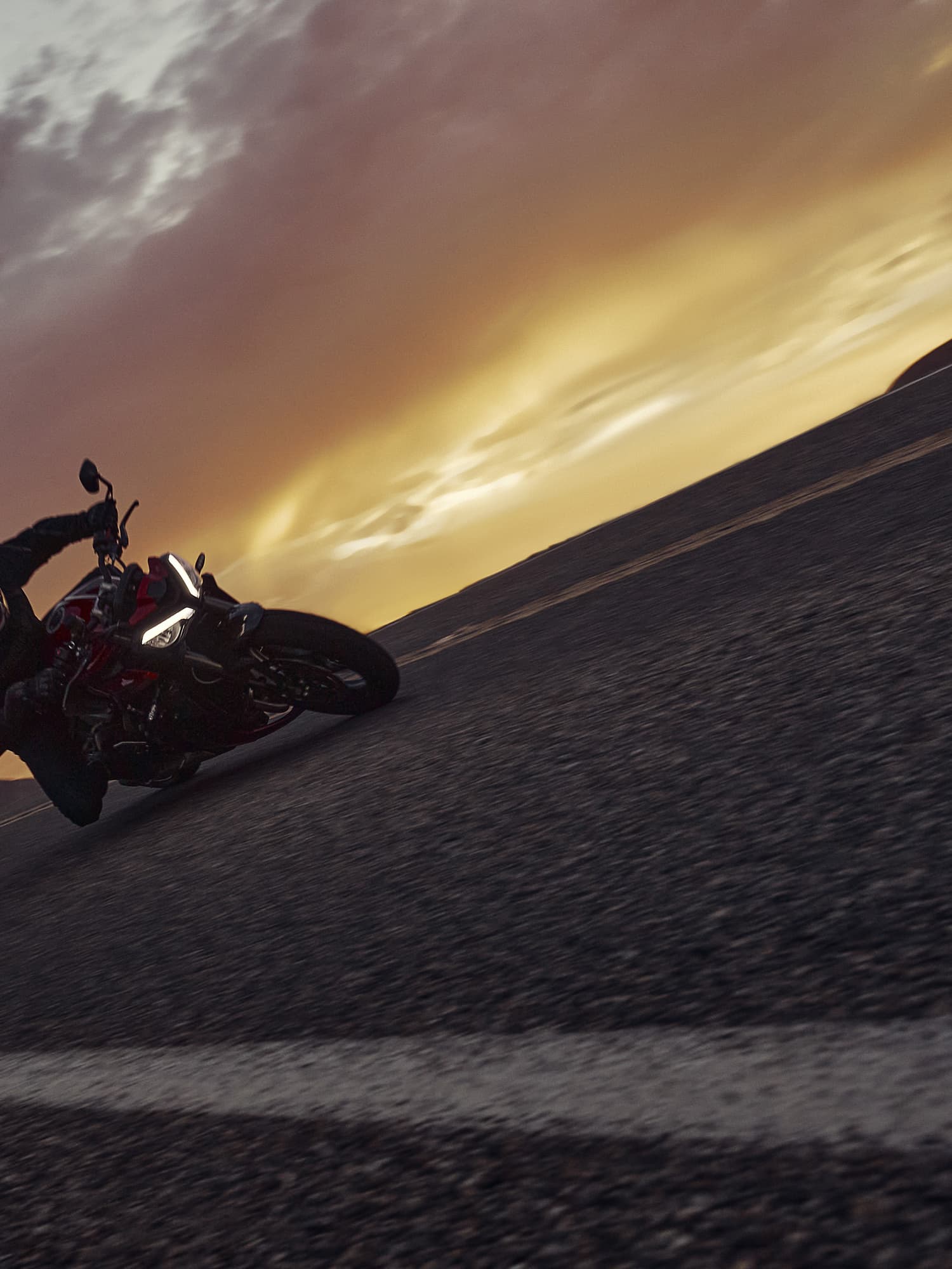 Triumph Street Triple 765 RS riding shot at a low angle during sunset