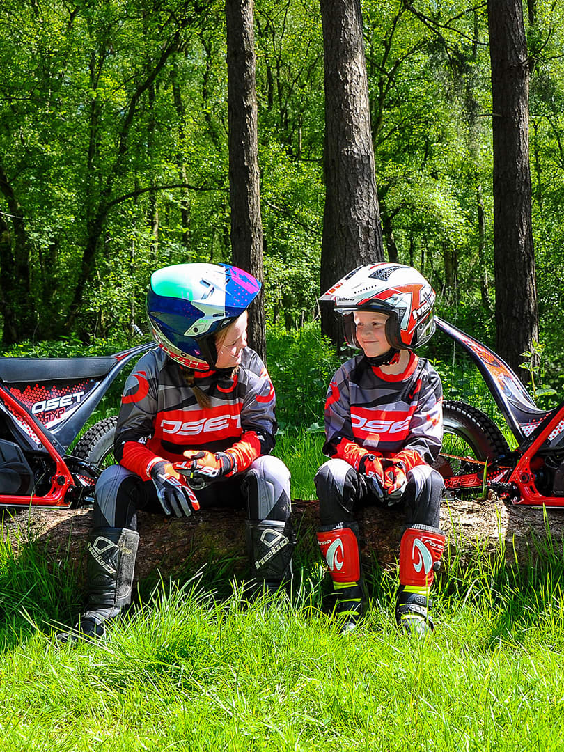 Two children sitting in front of the OSET electric bikes