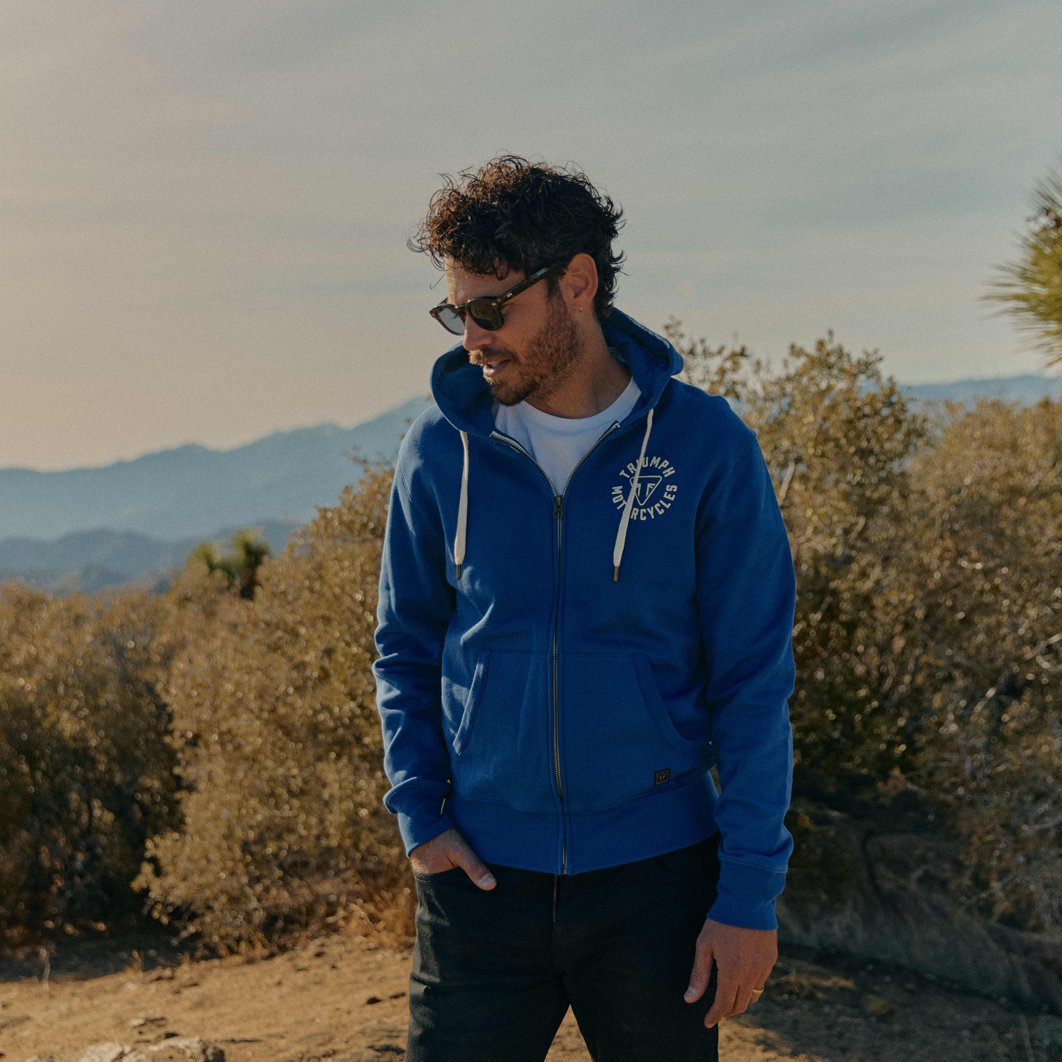 Man in the desert wearing a blue sweatshirt 