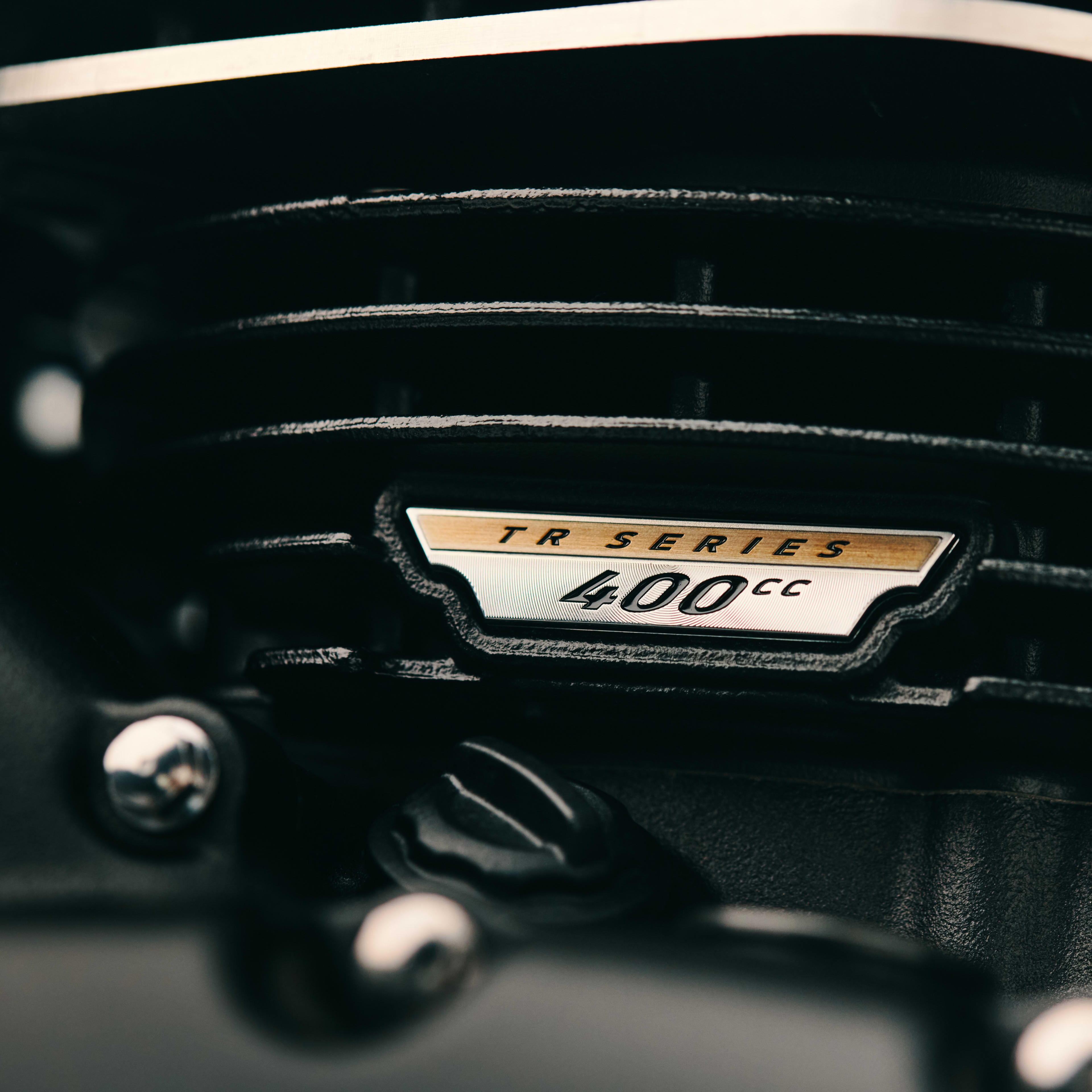 Le superbe moteur TR Series de 400 cm<sup>3</sup> affiche le profil épuré et minimaliste indissociable des Triumph Modern Classic. Les ailettes de refroidissement noires de la culasse et les grands supports de collecteur à ailettes rappellent les Bonneville du passé. Le carter moteur thermolaqué ajoute une touche moderne subtile qui renforce le caractère sombre de la T40 Black.