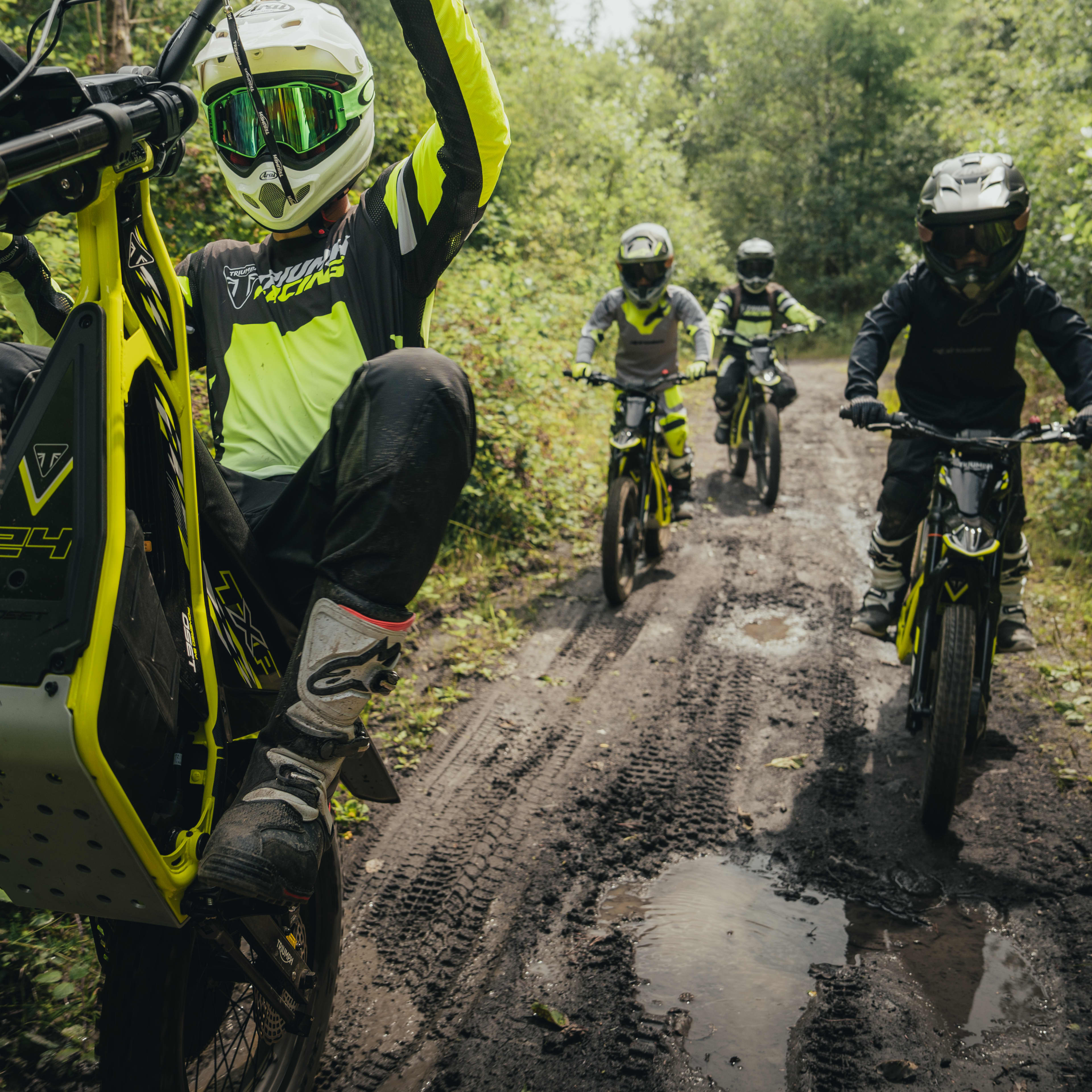 Purpose-built for every stage TXP powered by OSET bikes riding through a dirt track within a forest.
