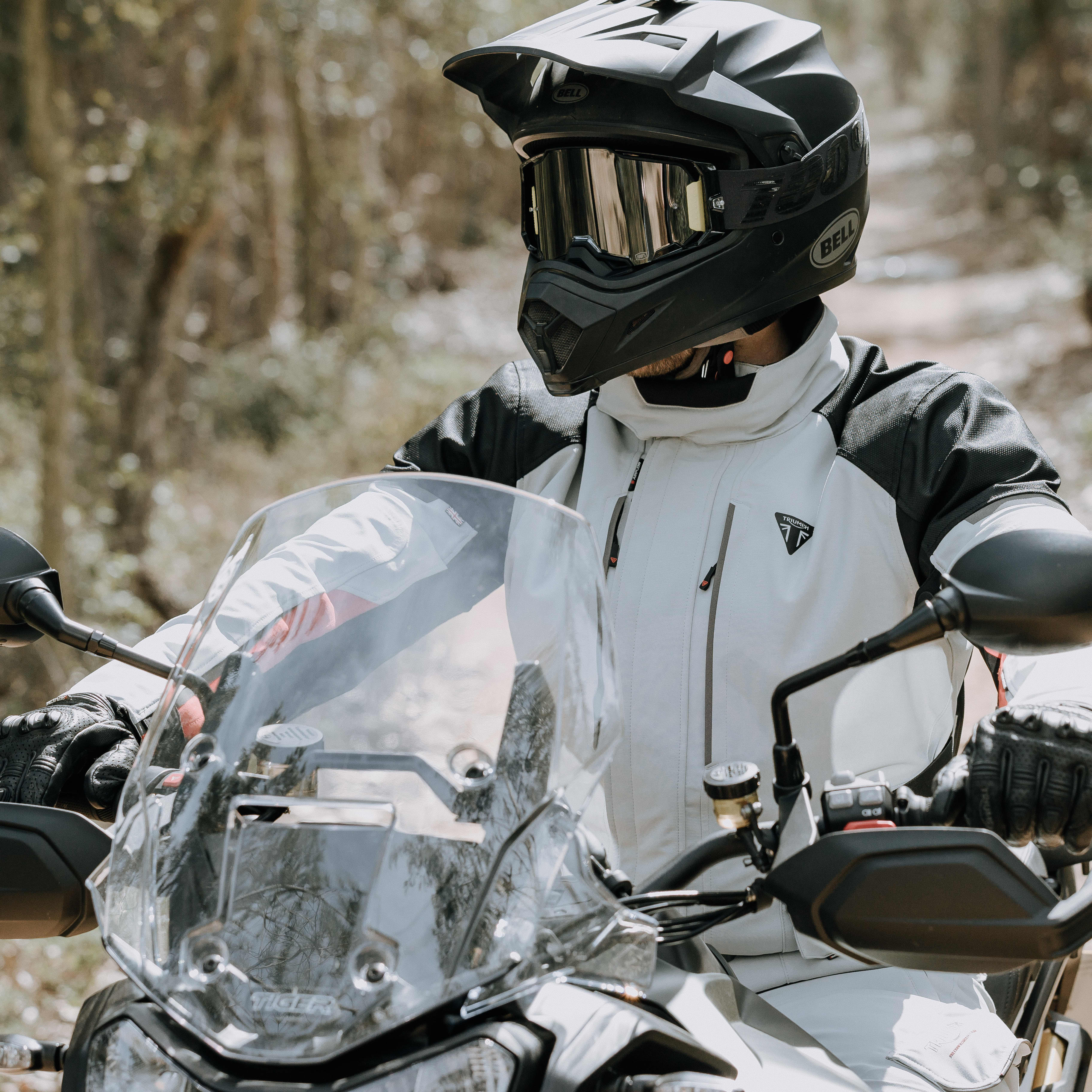 Mans back on a Triumph Motorcycle while wearing a yellow Triumph Braddan Jacket