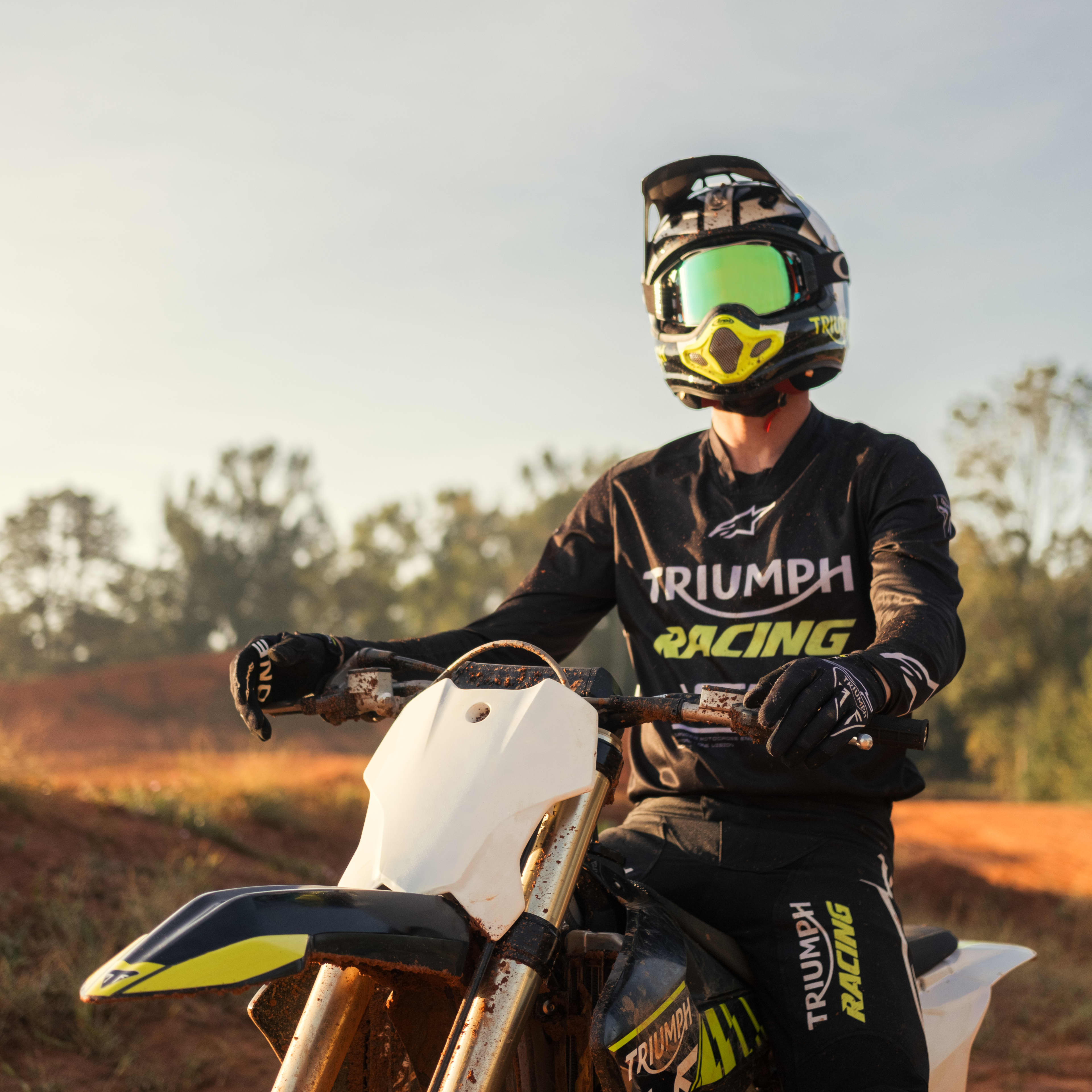 Mans back on a Triumph Motorcycle while wearing a yellow Triumph Braddan Jacket