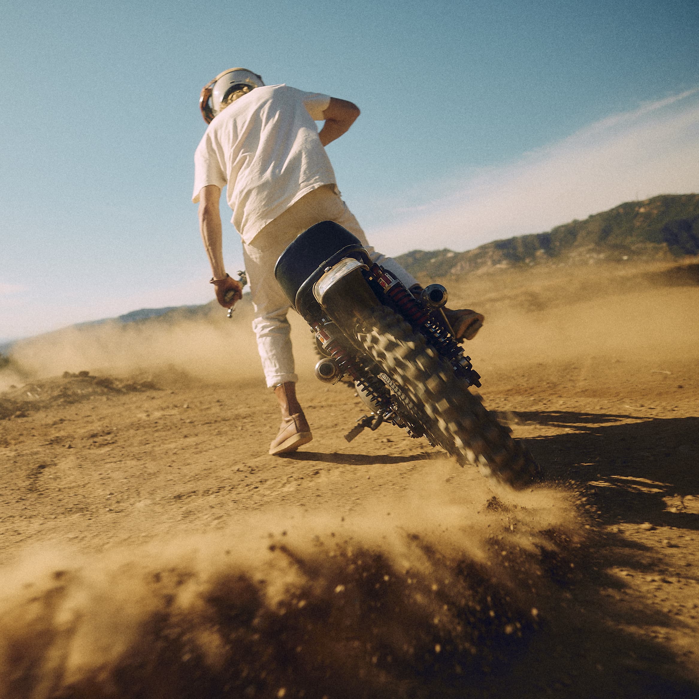 Man on vintage Triumph Motorcycle in the desert