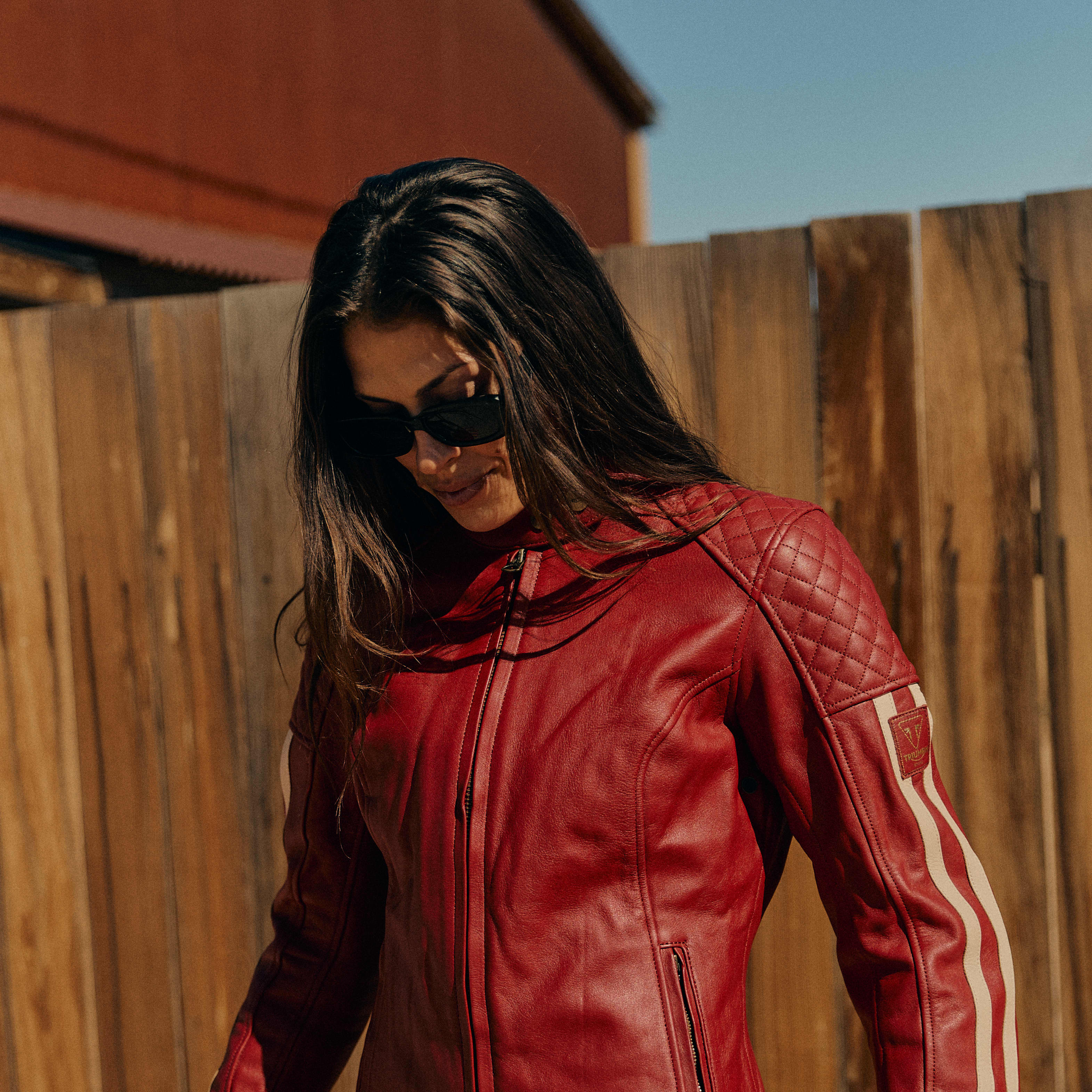 Mans back on a Triumph Motorcycle while wearing a yellow Triumph Braddan Jacket