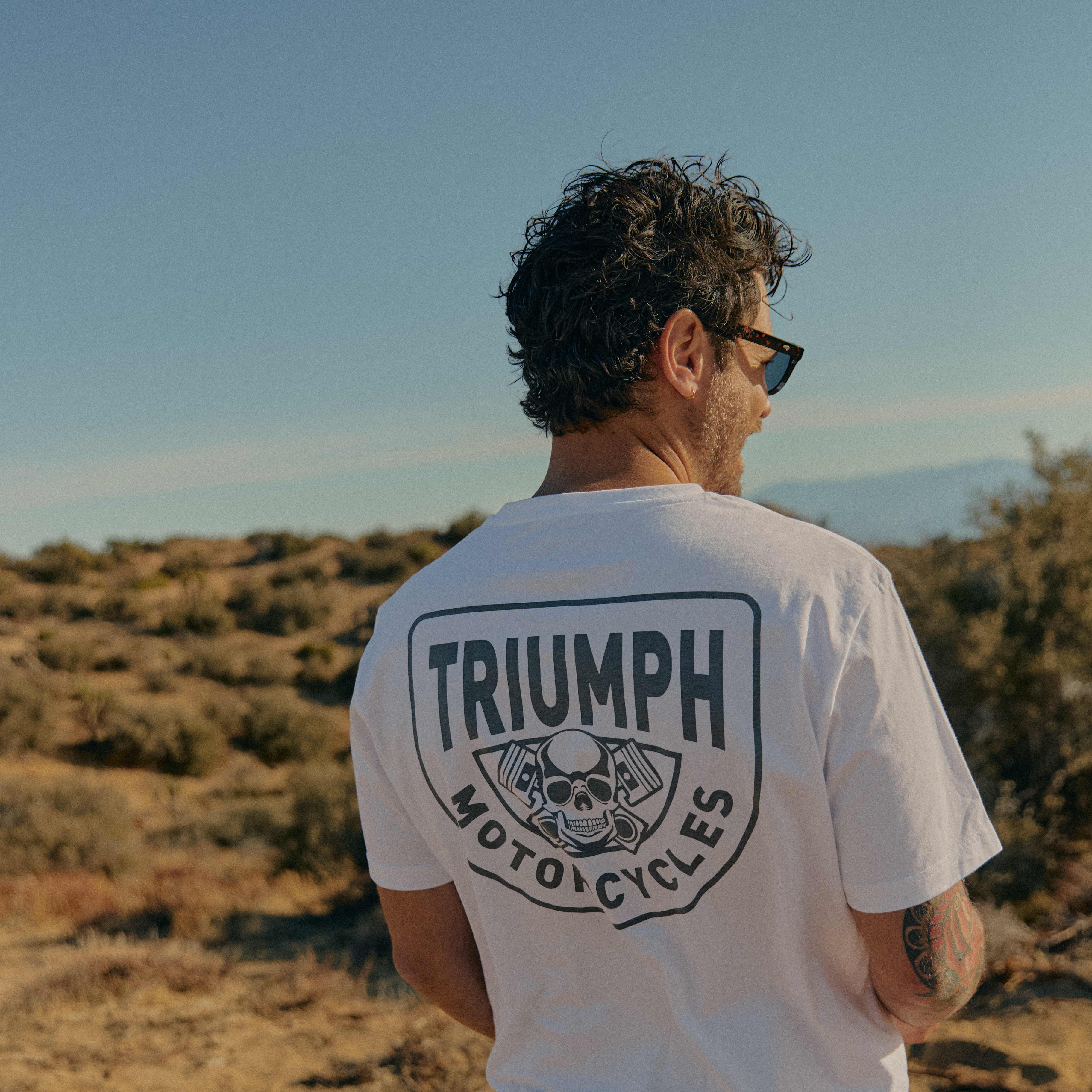 Man in the desert wearing a white Triumph Motorcycles T-shirt