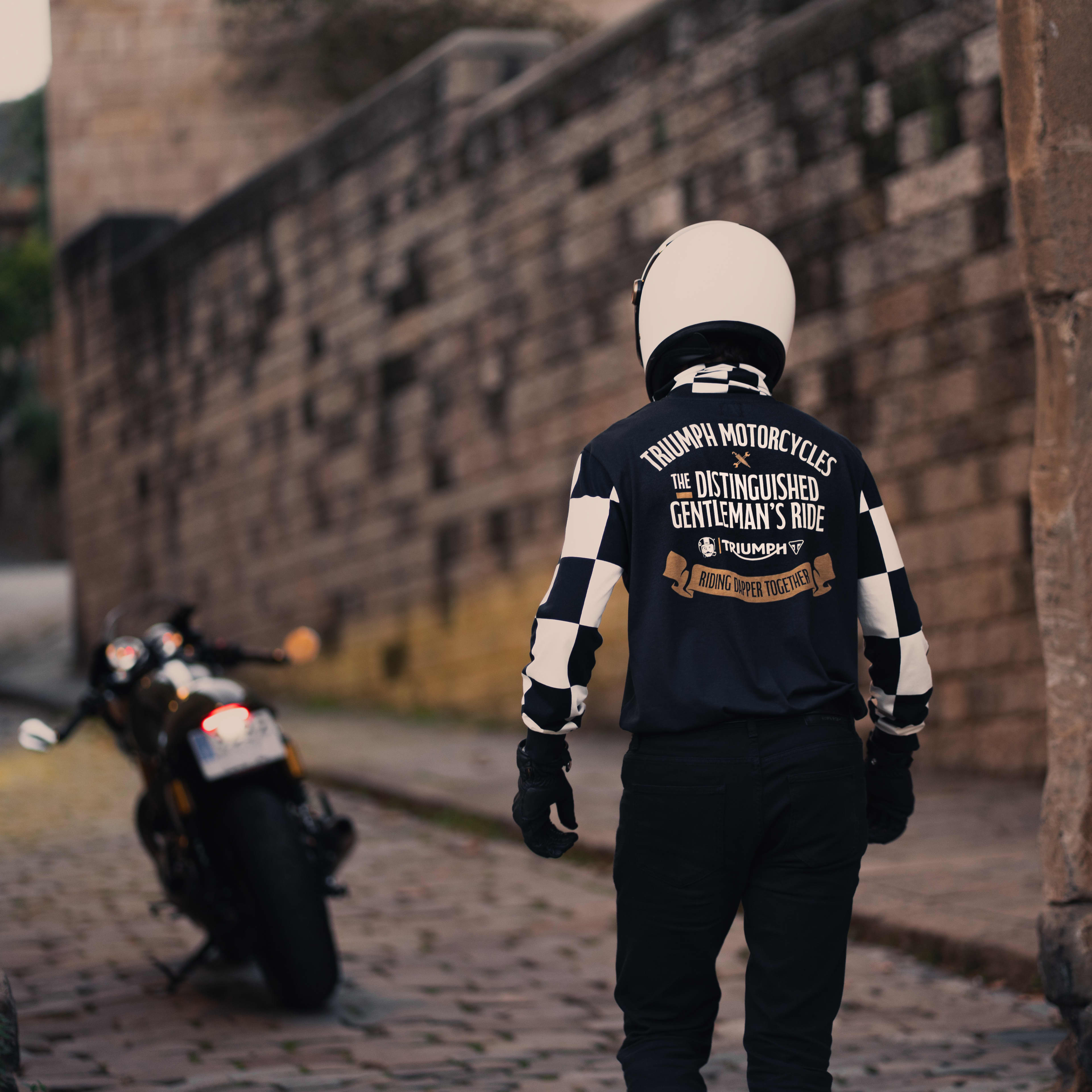 Man sitting on bike wearing a Triumph x DGR t-shirt