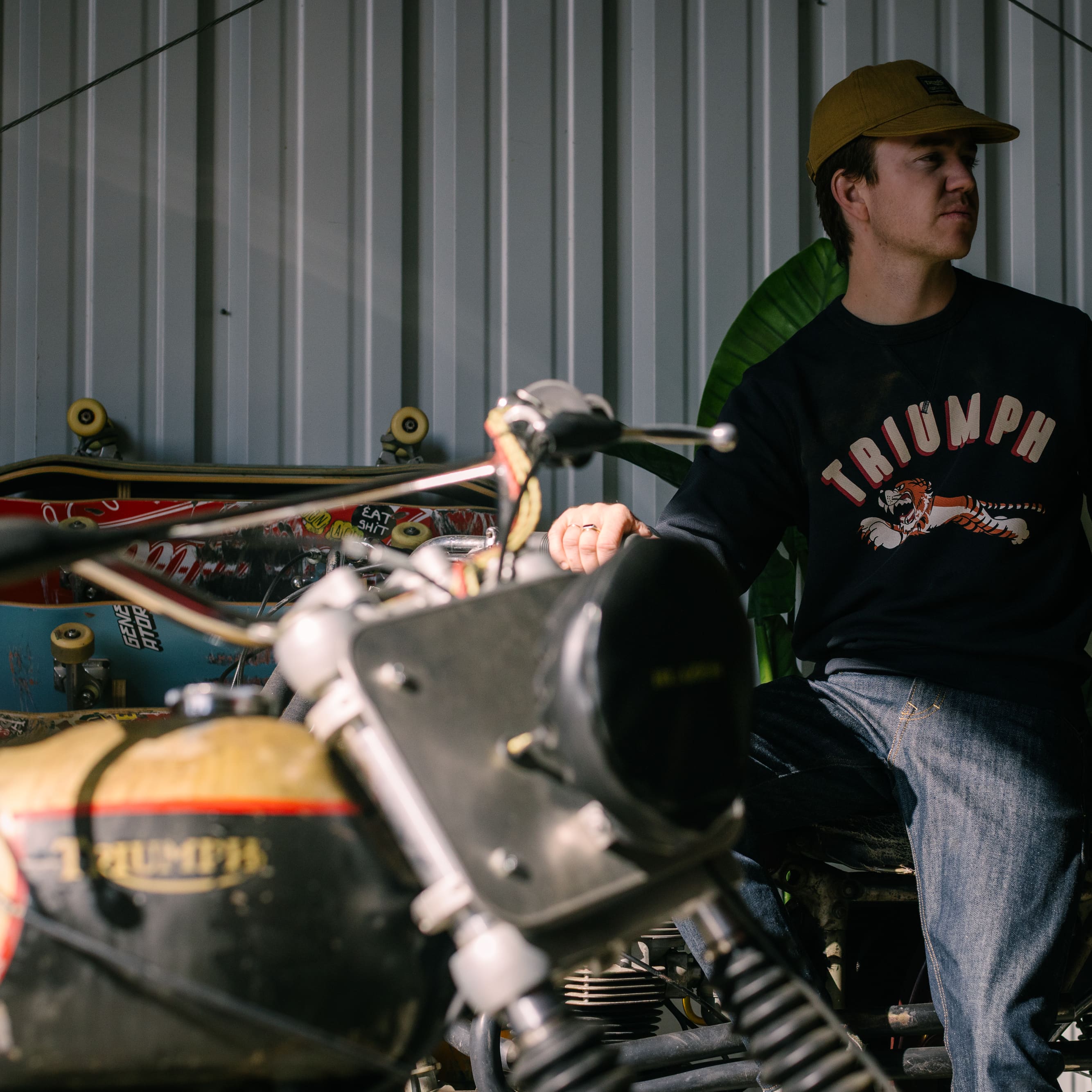 Man in a motorbike garage wearing a Triumph Heritage Sweatshirt