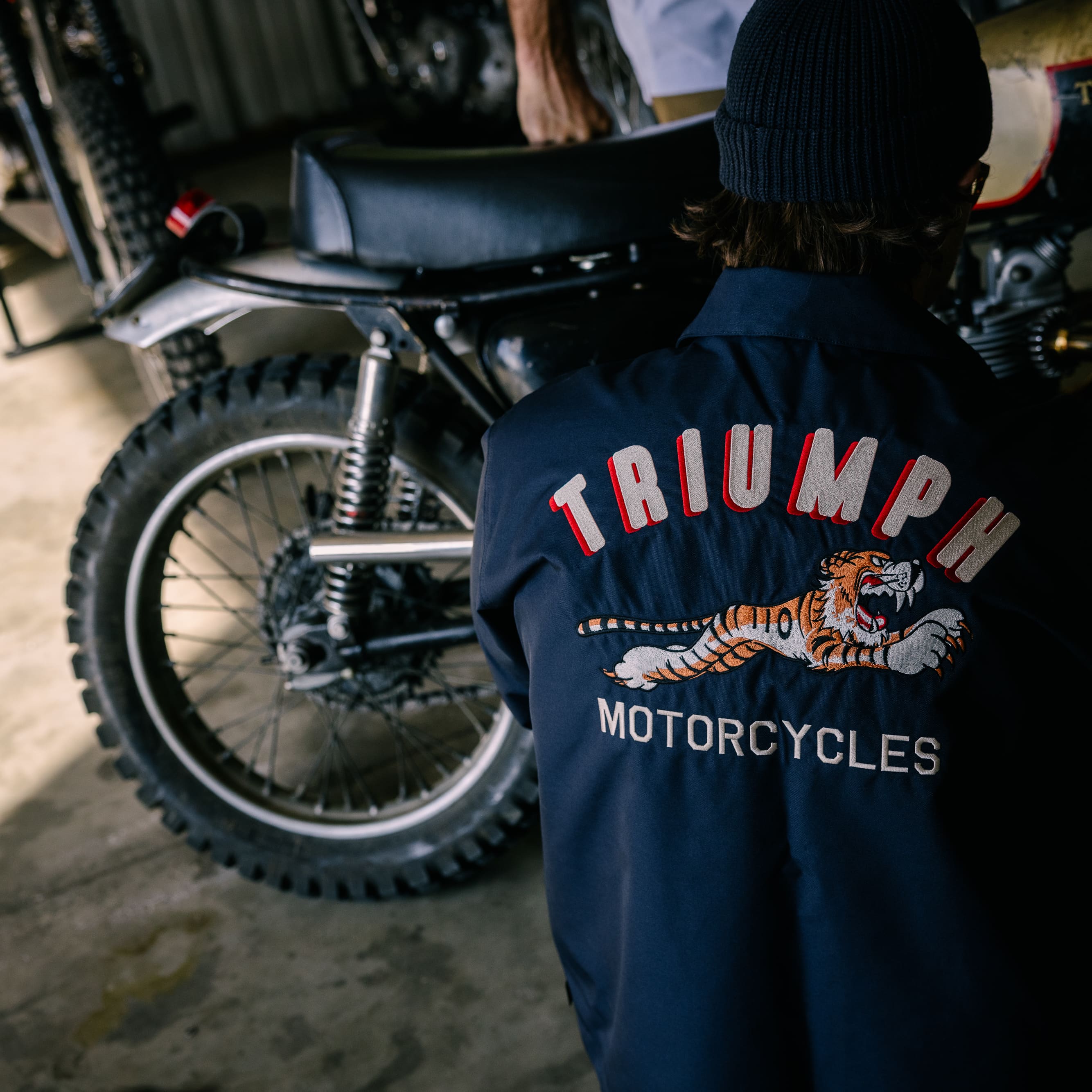 Man kneeling down wearing Triumph Heritage Jacket